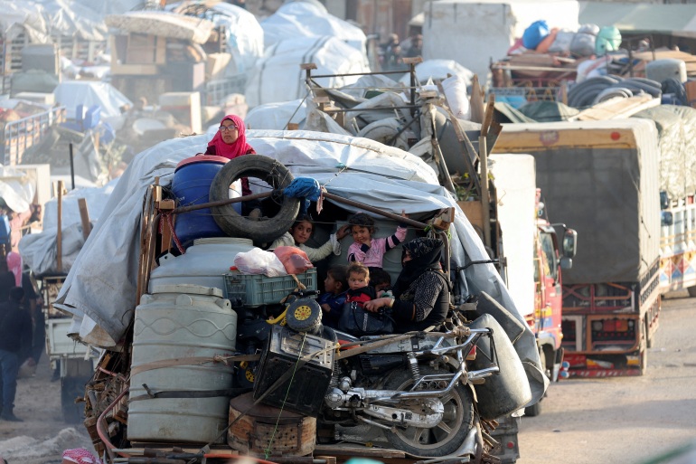 Syrian refugees sit with their belongings on a pick-up truck as they prepare to return to Syria from Wadi Hmayyed, on the outskirts of the Lebanese border town of Arsal, Lebanon October 26, 2022. REUTERS/Mohamed Azakir