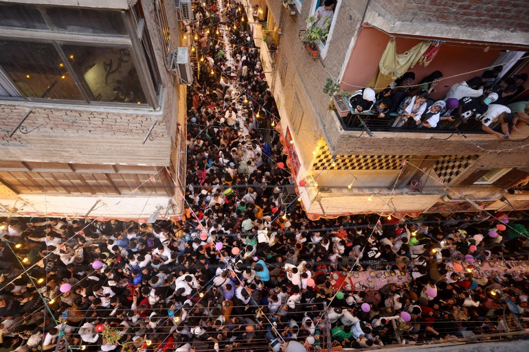 Egyptian residents of Ezbet Hamada in Cairo's Mataria district gather to eat Iftar, the meal to end their fast at sunset, during the holy fasting month of Ramadan in Cairo, Egypt March 15, 2025. REUTERS/Mohamed Abd El Ghany