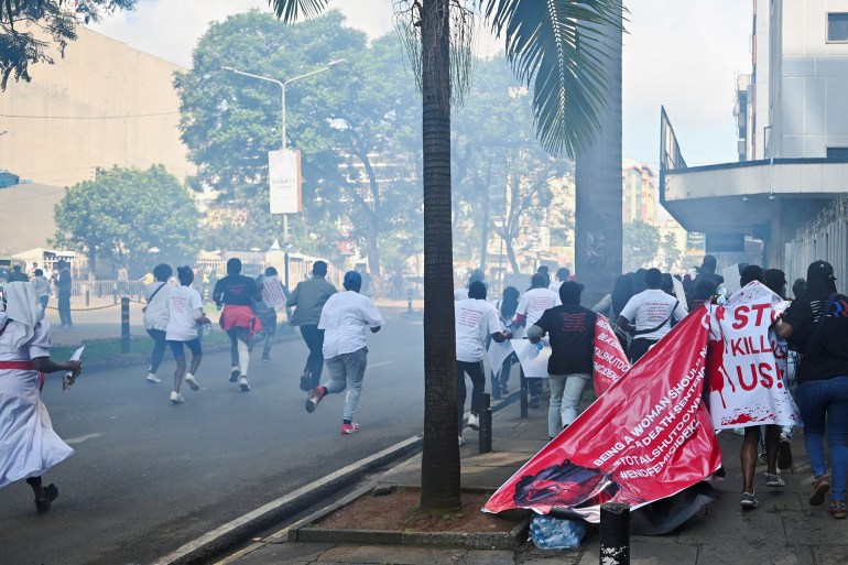 Activists and civil society members run, after riot police lobbed teargas canisters to disperse them, as they participate in a nationwide march titled “End Femicide Kenya" to raise awareness about gender-based violence (GBV) and to pressure the Kenyan government to implement stricter laws and policies to combat this pervasive issue, in downtown Nairobi, Kenya December 10, 2024. REUTERS/John Muchucha