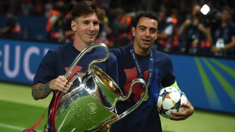 Barcelona's midfielder Xavi Hernandez (R) and Barcelona's Argentinian forward Lionel Messi celebrate with the trophy after the UEFA Champions League Final football match between Juventus and FC Barcelona at the Olympic Stadium in Berlin on June 6, 2015. FC Barcelona won the match 1-3. AFP PHOTO / PATRIK STOLLARZ (Photo credit should read PATRIK STOLLARZ/AFP/Getty Images)
