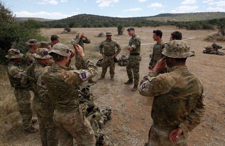 Britain's Prince William, center right, speaks to soldiers during a visit to the 1st Battalion the Irish Guards battle group, training under the British Army Training Unit Kenya (BATUK), in his role as Colonel of the Regiment, in Laikipia, Kenya Sunday, Sept. 30, 2018. Britain's Prince William, who has campaigned against the killing of elephants, rhinos, and other species, is in Africa this week to discuss threats to conservation ahead of a London conference on the illegal wildlife trade. (Thomas Mukoya/Pool via AP)