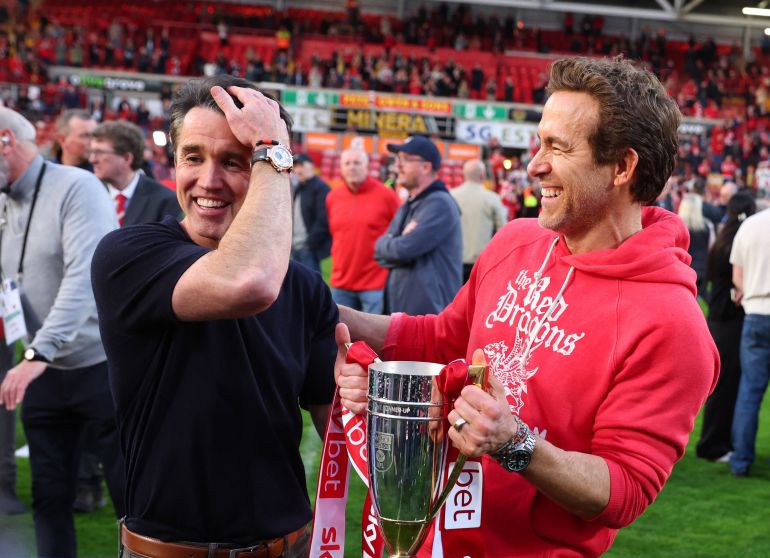 يحتفل الممثلون وأصحاب Wrexham Rob McElhenney و Ryan Reynolds مع كأس بعد ترقيته إلى البطولة 